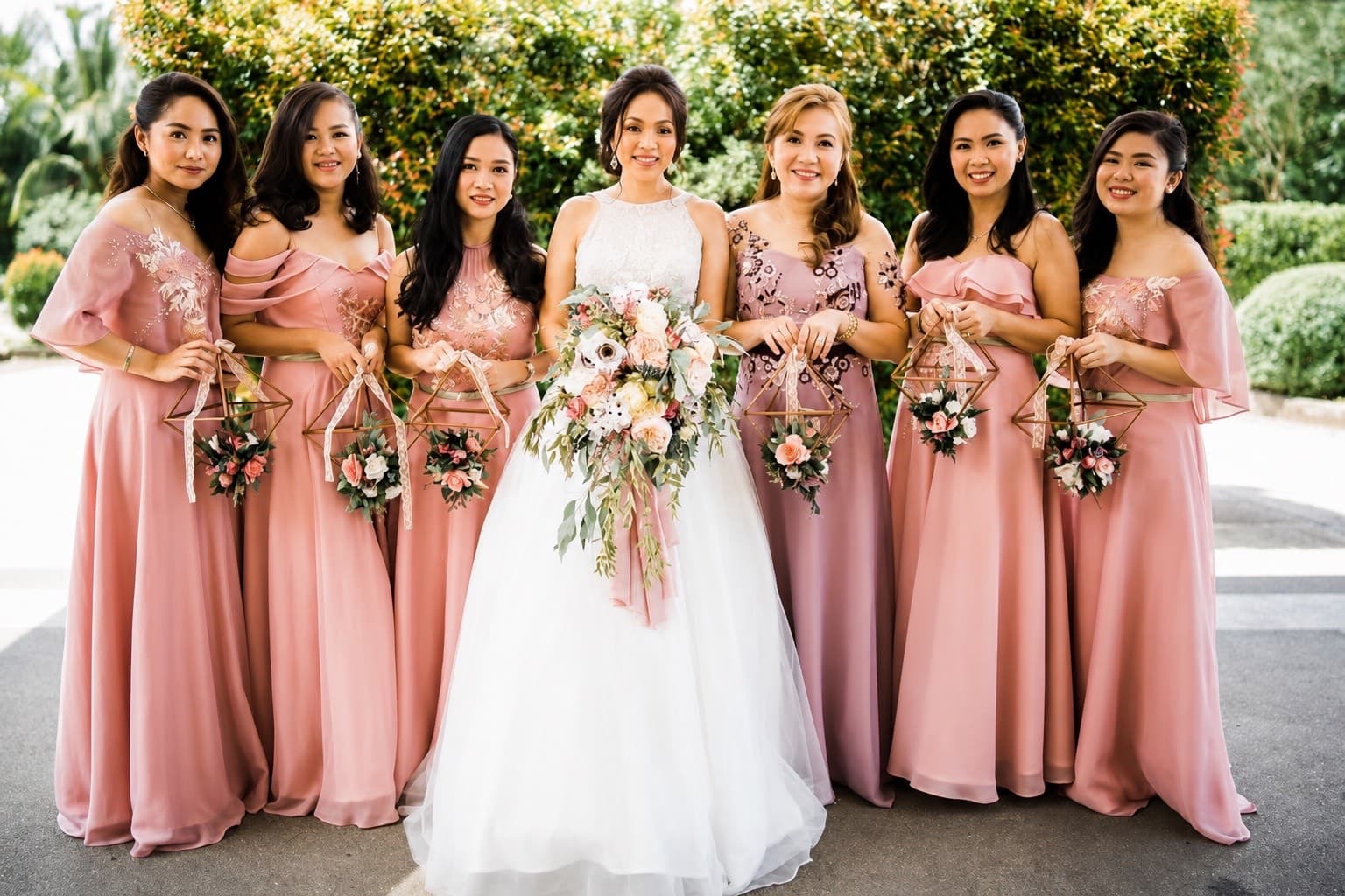 Bridesmaids in blush gowns holding geometric lantern bouquets